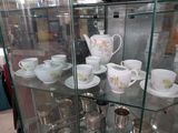 de nombreuses tasses et soucoupes exposées dans une vitrine