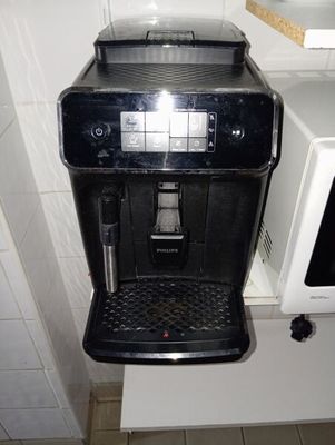 une machine à café noir posée sur un plan de travail dans une cuisine