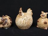 trois figurines d'animaux posées sur une surface noire