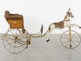 a toy horse pulling a carriage with a horse on it