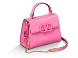 un sac à main rose avec une chaîne dorée sur fond blanc