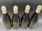 four bottles of wine are lined up on a table