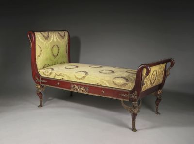 un banc rouge dont l'assise est recouverte d'un tissu jaune et vert
