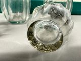 a glass of water sitting on a table next to a glass of water