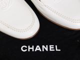 chanel shoes on a black bag on a wooden floor