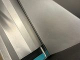 someone is using a machine to cut a piece of metal on a conveyor belt