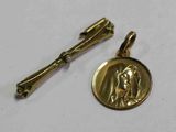 un gros plan sur une médaille et un pin's posés sur une surface blanche