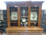 a wooden china cabinet with glass doors in a room