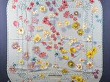 embroidered table cloth with flowers and leaves on a blue background