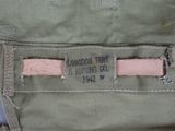 the back of a pair of green pants with a pink stripe