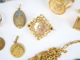 a lot of gold jewelry on a white surface