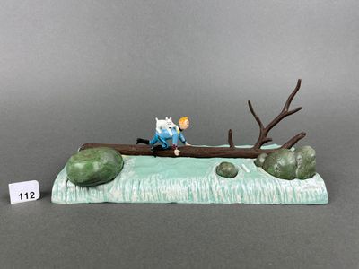 a figurine of a man sitting on a tree branch