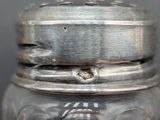 a glass jar with a silver lid on a table