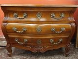 a wooden chest of drawers with brass handles on it