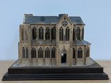 a small model of a building on a wooden table