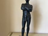 a statue of a man standing with his arms crossed