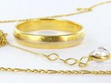 un collier sur lequel sont accrochées une bague, une bague, une bague et encore une bague