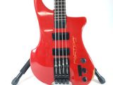 a red electric bass guitar on a stand on a white surface