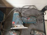 a corded sander, a drill, and two other tools on the floor