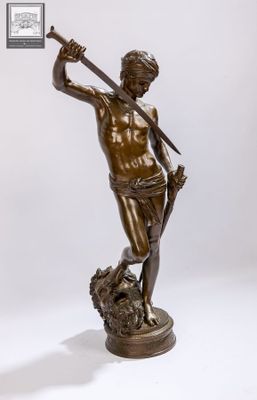 statue en bronze représentant un homme tenant une épée, debout sur un rocher