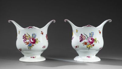 deux vases blancs ornés de motifs floraux, placés l'un à côté de l'autre
