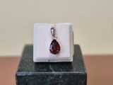 a close up of a ring with a red stone in it on a marble block