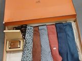 cinq cravates dans une boîte, avec une ceinture et des lunettes de soleil