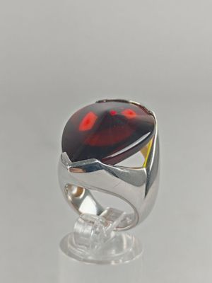 a close up of a ring with a red stone on it