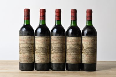 four bottles of wine are lined up on a wooden table