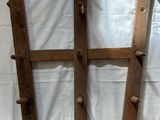 a wooden rack with four wooden pegs attached to it