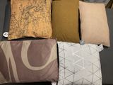 four pillows that are sitting on a black couch