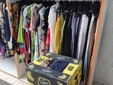 a rack with clothes and boxes on it in a store