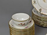 many plates, cups and saucers that are on the table