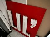 a red door with white letters on it next to a white door