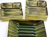 three green and gold striped dishes on a white surface