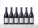 six bottles of wine lined up in a row on a table