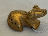 une figurine d'éléphant en or posée sur une surface blanche
