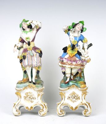 une paire de figurines en porcelaine représentant une femme et un homme, posées sur des socles