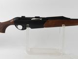 le fusil est posé sur un socle transparent, sur une surface blanche