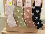 three pairs of women ' s socks are on a pallet in front of a box