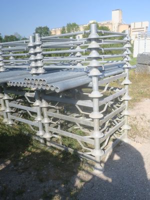 une clôture métallique à laquelle sont fixés plusieurs tuyaux