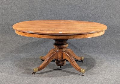 une petite table ronde avec un plateau en bois, montée sur roulettes