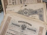 deux vieux billets de banque posés sur une table, à côté d'une paire de ciseaux