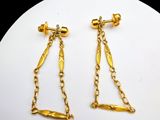 pair of gold plated earrings with chains on a white plate