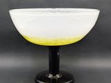 a white and yellow bowl sitting on top of a black base