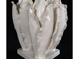 un vase blanc contenant un bouquet de coquillages