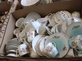 a box full of tea cups and saucers sitting on a table