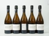 quatre bouteilles de vin sont alignées sur une surface blanche
