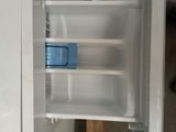 a white refrigerator with a blue handle in a room