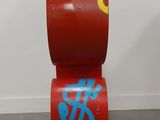 a red skateboard with graffiti on it in the middle of a room